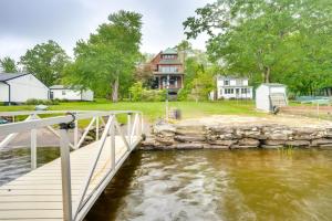 a bridge over a river with a house in the background at Luxe Family Home on Orange Lake with Private Dock! in Newburgh