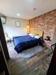 a bedroom with a blue bed and a brick wall at C46-R01 STUDIO at ITESM CEM Families Tourists & Travelers Choice Foreign Students Companies Executives WELCOME!!! 10min Izcalli-15min Esmeralda-20min Sátelite-25min AIFA in Mexico City