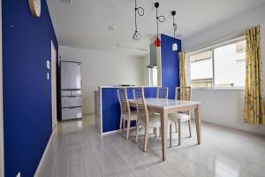 eine Küche und ein Esszimmer mit Tisch und Stühlen in der Unterkunft ブルースカイ富士 in Fujikawaguchiko