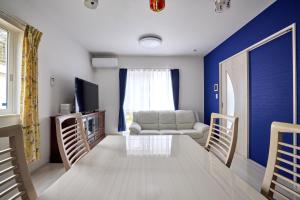 ein Wohnzimmer mit Sofa und Tisch in der Unterkunft ブルースカイ富士 in Fujikawaguchiko