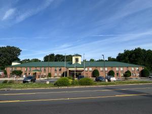 a large brick building with a green roof on a street at Blue Star Inn in Spartanburg