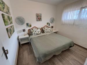 een slaapkamer met een bed met 2 tafels en een raam bij Callao Sunset Home in Callao Salvaje