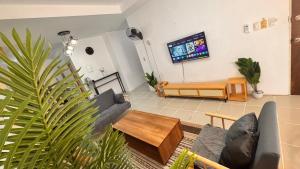 a living room with a couch and a tv at Hidden Leaf Villa in Caoayan