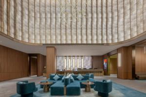 a lobby with blue chairs and a large ceiling at 西安明城墙永兴坊桔子水晶酒店 in Xi'an
