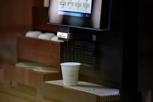 a coffee cup sitting on a shelf next to a tv at 西安明城墙永兴坊桔子水晶酒店 in Xi'an