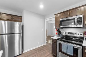 une cuisine avec des appareils en acier inoxydable et des armoires en bois dans l'établissement 1-Mile to Downtown Clarksville Cozy in Queen-City, à Clarksville