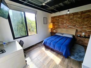 メキシコシティにあるR09 STUDIO CORNER at ITESM CEM Full Services, Shared-Kitchen, Fridge ,Laundry, Smart TV, Parking, Balconyのベッドとレンガの壁がある寝室