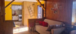 a living room with a couch and a kitchen at Le petit coin de Lea in Quart