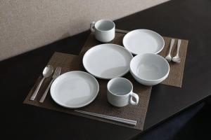 a table with white plates and cups and utensils at クレストコート北大前 in Sapporo