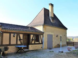 une petite maison avec une table en face dans l'établissement Studio paisible près de La Roque-Gageac avec parking - FR-1-616-25, à La Roque-Gageac