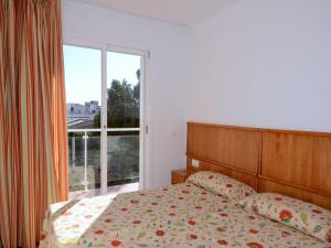 a bedroom with a bed and a large window at Spacious duplex Apartment in Estartit in L'Estartit