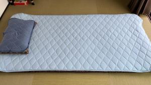 un lit blanc avec un oreiller violet sur le sol dans l'établissement Awaji Island Trailer House Rental Villa Yunetomari Akashi, à Awaji