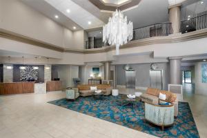 a lobby of a hotel with couches and a chandelier at DoubleTree by Hilton Hotel West Palm Beach Airport in West Palm Beach