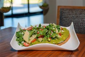 a plate of food with a salad on a table at DoubleTree by Hilton Hotel West Palm Beach Airport in West Palm Beach