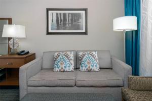 a living room with a couch in a hotel room at DoubleTree by Hilton Hotel West Palm Beach Airport in West Palm Beach