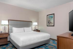 a hotel room with a bed and a flat screen tv at DoubleTree by Hilton Hotel West Palm Beach Airport in West Palm Beach