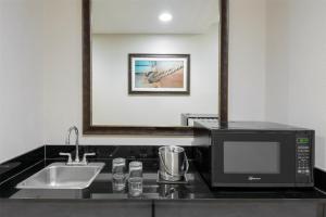 a kitchen with a microwave and a sink at DoubleTree by Hilton Hotel West Palm Beach Airport in West Palm Beach