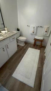 a bathroom with a toilet and a white rug at The Monroe Elegant 2BR2BA Downtown Stamford in Stamford +19 photos