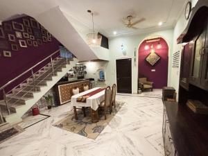 a dining room with purple walls and a staircase at Otla - A Heritage Boutique Hotel, Jaipur in Jaipur