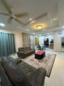 Pinggir TTDI Damansara Homestay for big group up to 35 pax في كوالالمبور: غرفة معيشة مع أريكة جلدية وطاولة +26 صورة