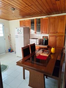 a kitchen with a wooden table and a refrigerator at Casa Aconchego Serrano in Campos do Jordão