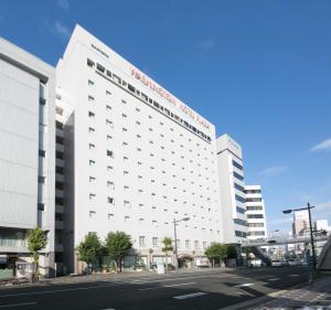 Un gran edificio blanco en una calle de la ciudad. en Tokushima Washington Hotel Plaza, en Tokushima