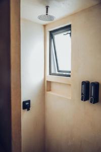 a bathroom with a window and speakers on the wall at Wander Cabins Dehe  +16 photos