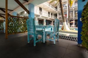 a table and chairs on a balcony with a pool at Hotel Playa Paraíso in Monterrico