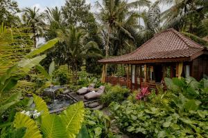 una pequeña casa en medio de un jardín en Anantra Bali Eco Villa, en Ubud