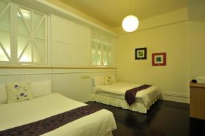 a hotel room with two beds and a window at 朝日民宿 可包棟 in Taitung City +13 photos