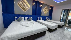 a bedroom with two beds with a heart shaped pillow at Art Nara Hotel อาร์ตนรารีสอร์ท in Narathiwat