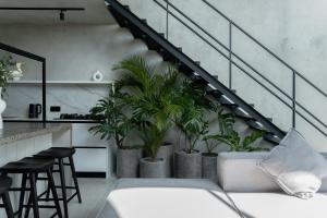 a living room with a staircase with potted plants at Predmet Babakan Canggu Bali in Dalung