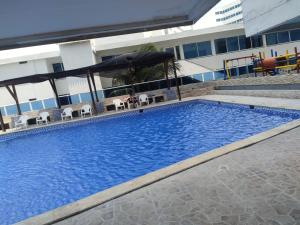 a large blue swimming pool in front of a building at Apartamento cerca Bocagrande in Cartagena de Indias +6 photos