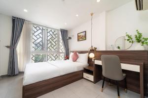 a bedroom with a bed and a desk and a chair at Galaxy Boutique Sai Gon Central Hotel in Ho Chi Minh City