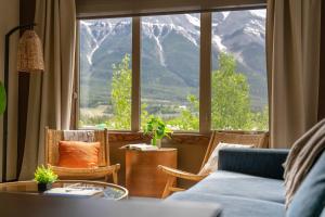 ein Wohnzimmer mit Couch und großem Fenster in der Unterkunft Breathtaking Luxury 3Bd Penthouse Pool and Hot Tub in Canmore