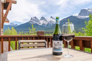 eine Flasche Wein auf einem Tisch mit einem Glas in der Unterkunft Breathtaking Luxury 3Bd Penthouse Pool and Hot Tub in Canmore