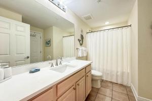 a bathroom with a sink and a toilet and a mirror at Crystal Tower 1408 - Lazy River, Beachfront pool, Amazing Views, New Upgrades!! in Gulf Shores