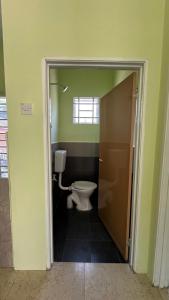 a bathroom with a toilet in a room with green walls at Baitul Ilmi Homestay in Kuala Kangsar