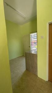 an empty room with green walls and a window at Baitul Ilmi Homestay in Kuala Kangsar