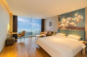 um quarto com uma cama grande e uma sala de estar em Magnotel Tongxiang Shimao Center em Tongxiang mais 36 fotografias