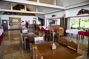 a restaurant with tables and chairs and people in the background at Namkhong Riverside in Chiang Khong