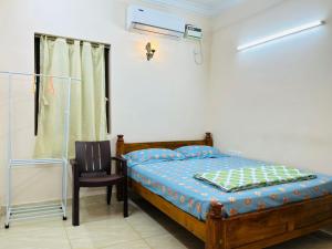 a bedroom with a bed and a chair and a window at Good stay TNagar in Chennai