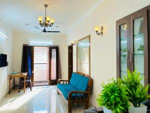 a living room with a blue chair and a table at Good stay TNagar in Chennai