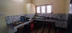 Una cocina con encimera de azulejos y una ventana. en AryaBhadhra Cottages 4 Room - 2, en Kochi