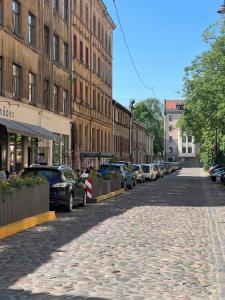 une rue pavée avec des voitures et des bâtiments en stationnement dans l'établissement Brand new apartment in a historical location, à Riga