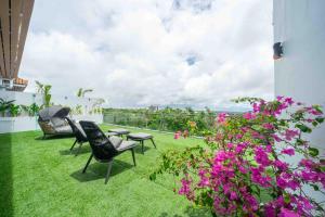a patio with chairs and flowers on the grass at Gandum Villa Complex - Luxury Boutique Stay Uluwatu in Uluwatu