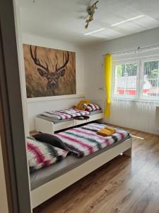 a bedroom with two beds and a painting on the wall at Ferienwohnung Dorfleben - 4 Schlafzimmer für Familien & Teams in Windisch Minihof