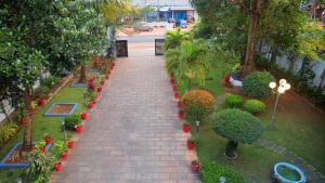 une allée en briques dans un parc avec des plantes et des arbres dans l'établissement Dazicor Retreats - Luxury Villa in Kottarakara, 