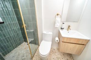 a bathroom with a toilet and a sink and a shower at Room 2 Stylish Escape by Calle Cerra Art in San Juan