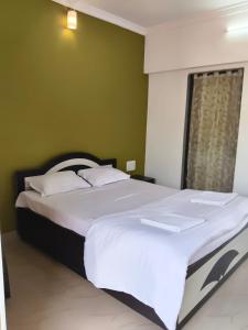 a large bed in a bedroom with a green wall at Panchgani Palace in Panchgani
